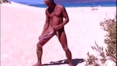 Tanned guy on beach in tiny string thong (temporarily!) on freefilmz.com