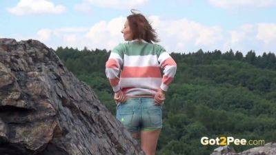 Pretty girl takes a piss while out walking in the country on freefilmz.com