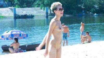 Nude beach girl chats with her friends lays naked and enjoys the sun on freefilmz.com