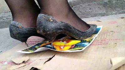 Girl stomping on picture in black metal high heels - India - Pakistan on freefilmz.com